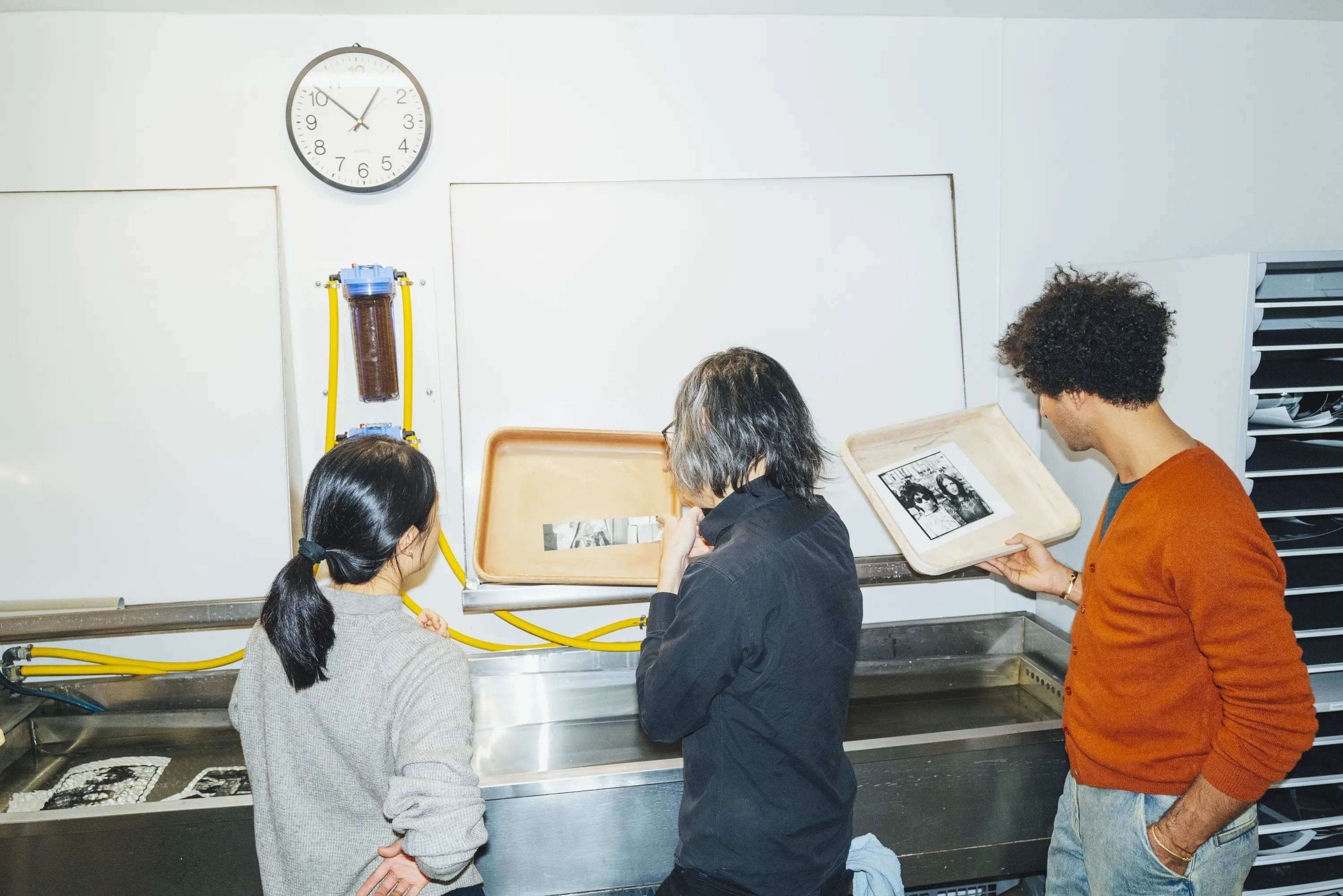Students and faculty member working in darkroom